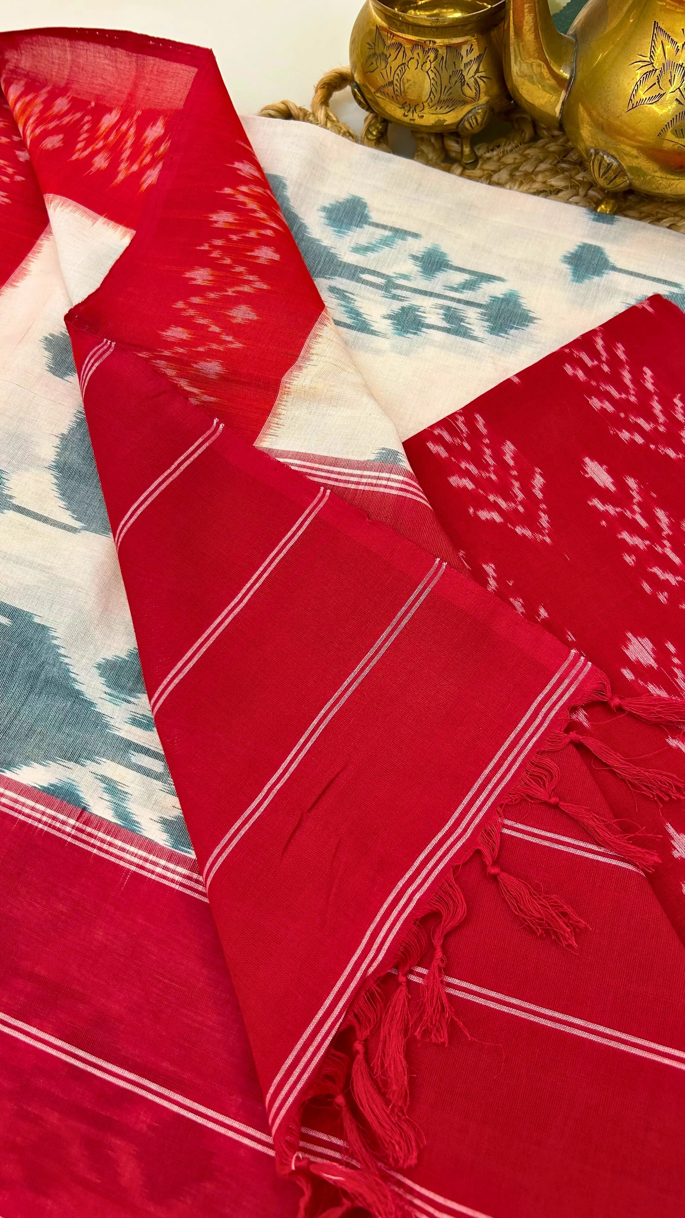 Handloom Ikkat cotton dupatta in deep red with fine white stripes and knotted tassels, showcasing traditional weaving details.