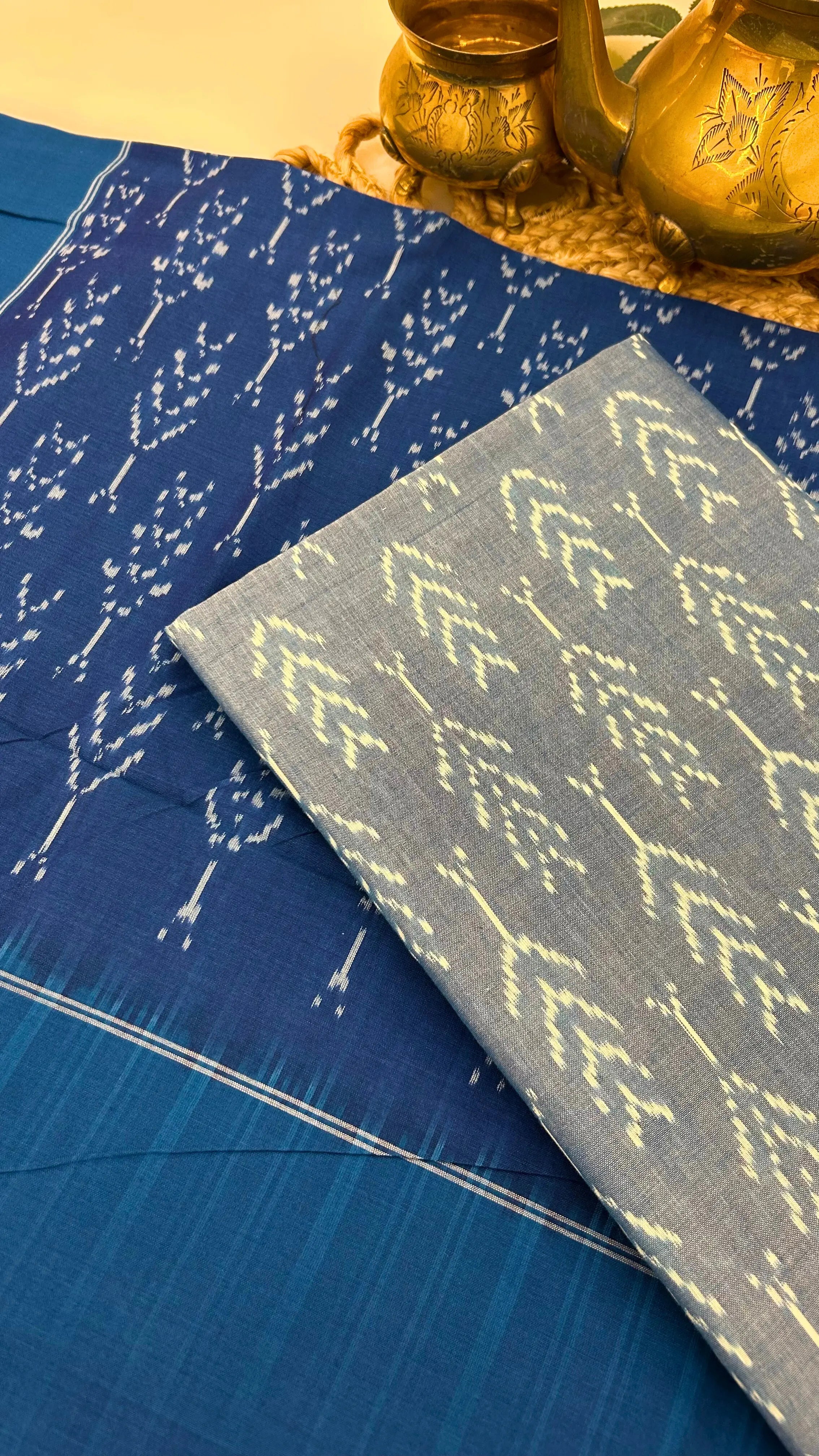 Close-up of Blue & grey Ikkat cotton fabric with resist-dyed motifs, highlighting handloom texture and craftsmanship.