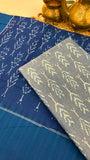 Close-up of Blue & grey Ikkat cotton fabric with resist-dyed motifs, highlighting handloom texture and craftsmanship.