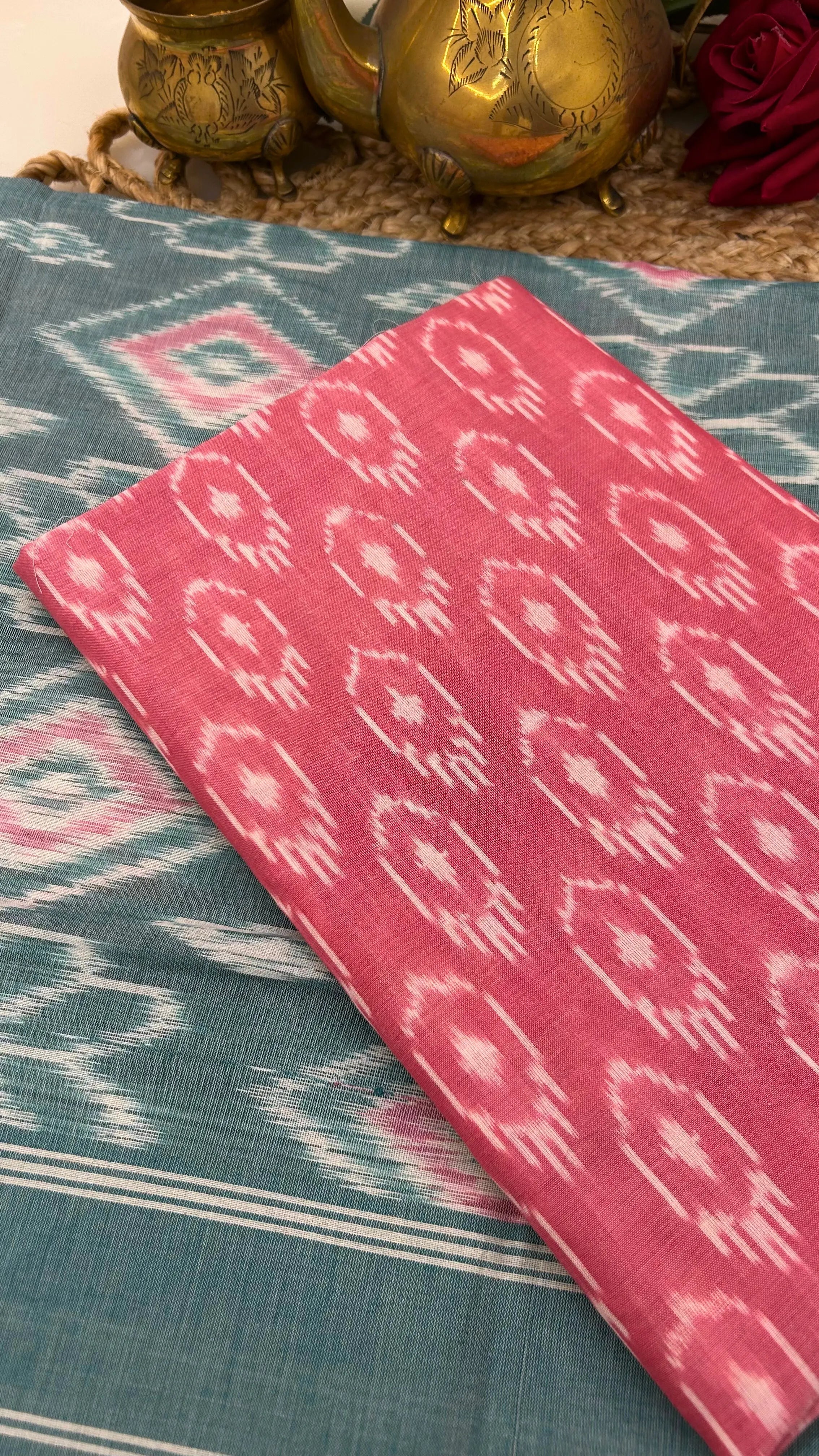Close-up of pink Ikkat cotton fabric with traditional resist-dyed motifs.