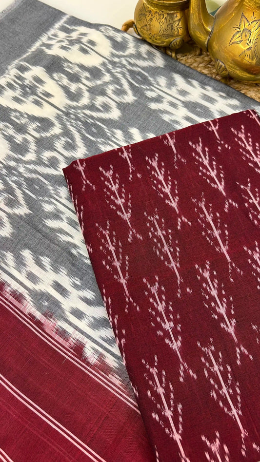 Close-up of maroon Ikkat cotton fabric with traditional resist-dyed motifs.