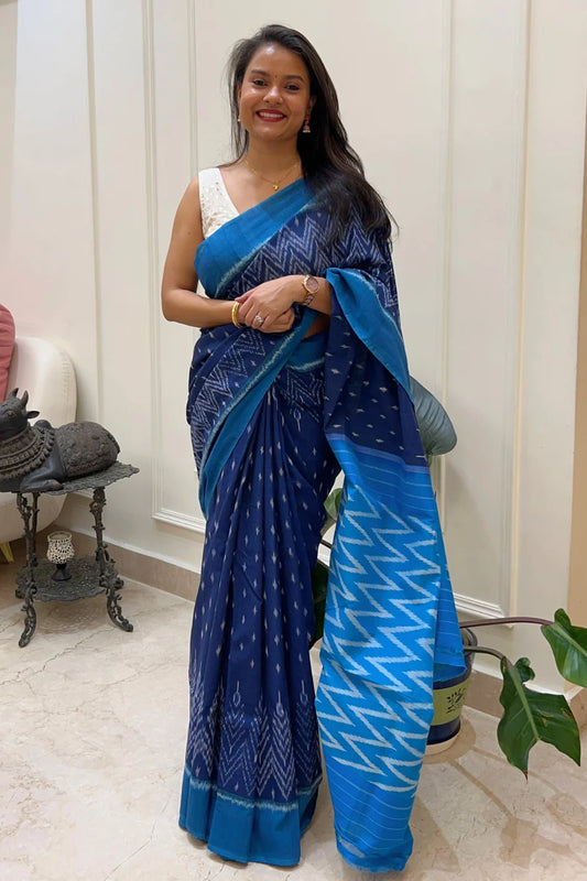 Woman wearing a blue Ikkat saree with a white background
